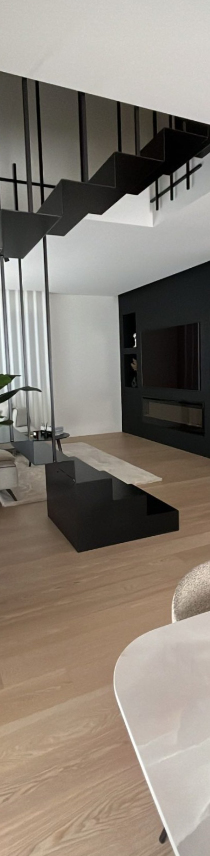 ifoto di un ambiente interno con scale, tavolo e salotto realizzato da Studio10