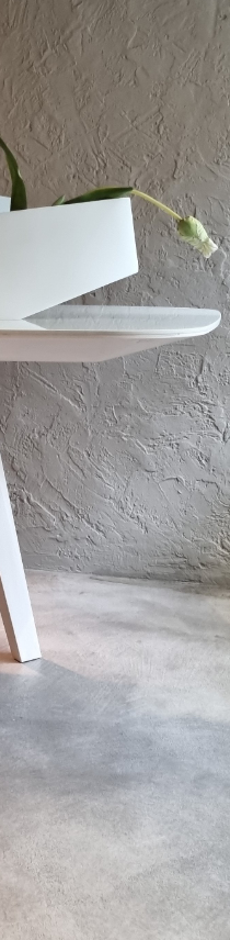 foto di un dettaglio di un tavolo bianco ed un vaso bianco appoggiato sopra realizzato da Studio10