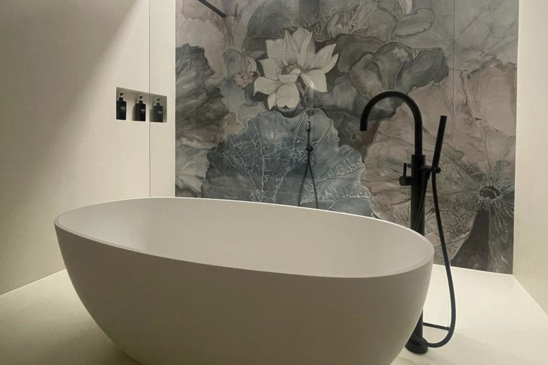 foto di un bagno con vasca di design e parete decorata con carta da parati di colore blu con fiori bianchi e foglie beije